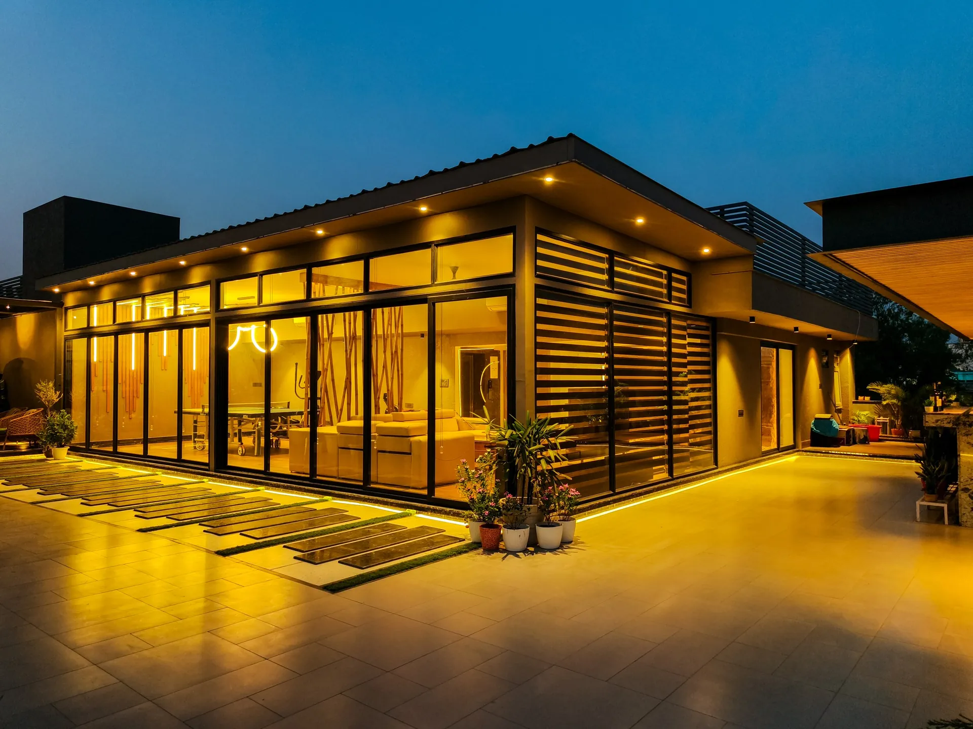 Terrace and glass pavilion lit up at night by LifeWall