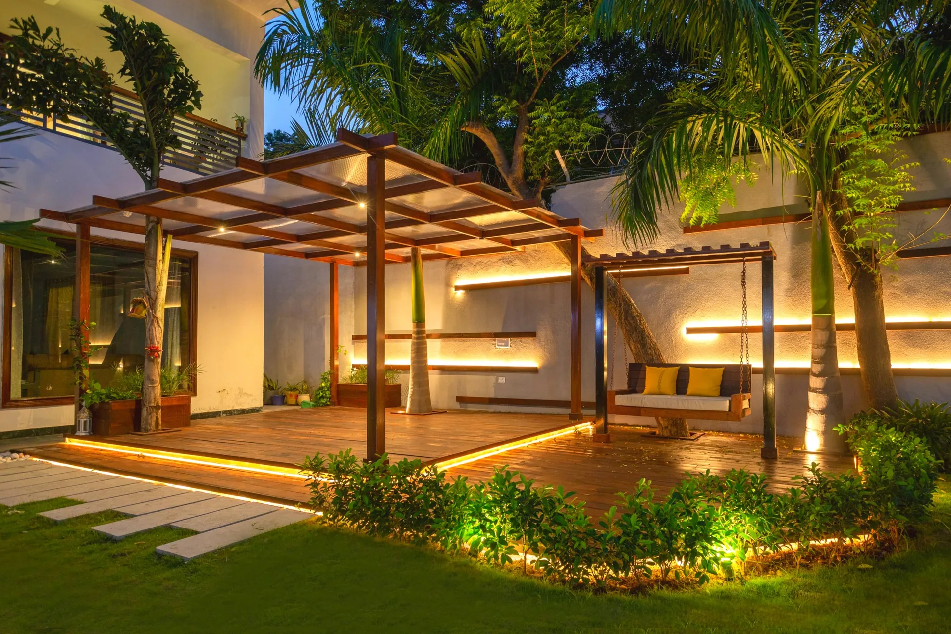 Backyard pergola deck with lounge seating and lighting by LifeWall
