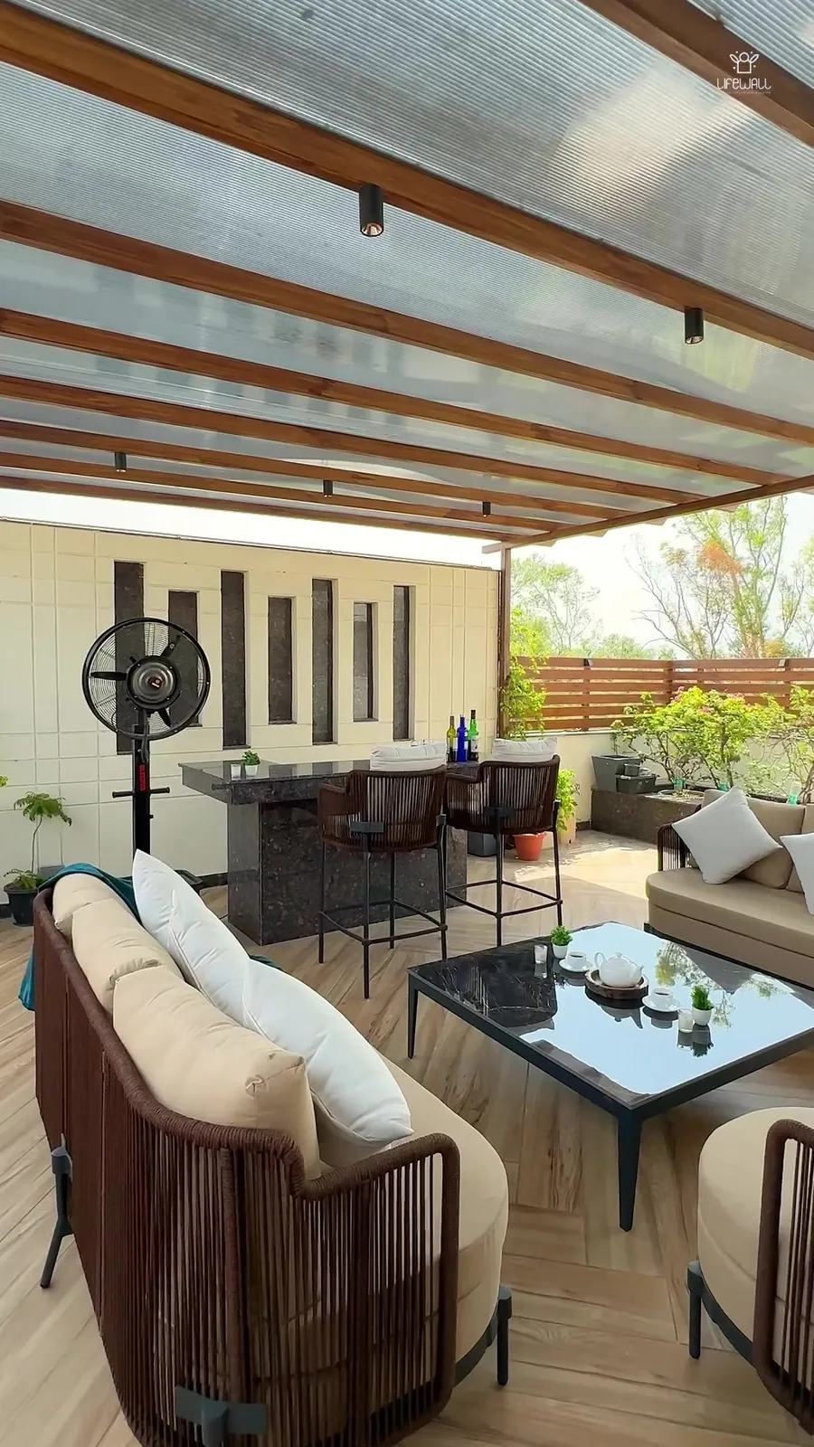Film of a terrace with stone water wall and pergola lounge
